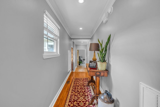 hall featuring light wood-style flooring, crown molding, baseboards, and recessed lighting