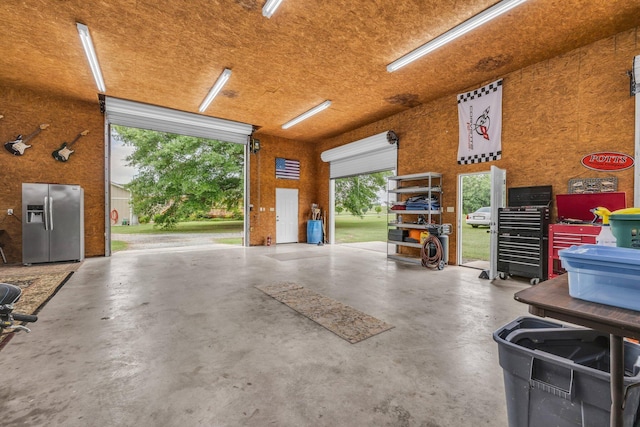 garage featuring stainless steel refrigerator with ice dispenser