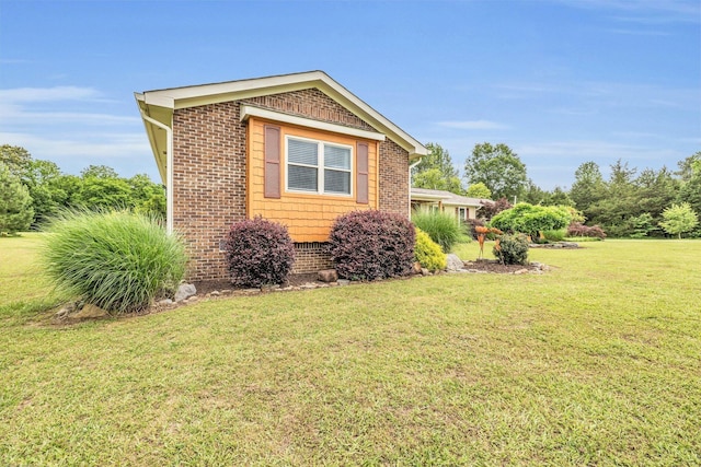 view of side of home with a lawn and brick siding