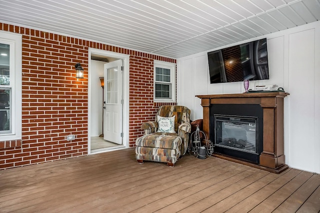 819 N Jefferson Ave, Cookeville, TN 38501 - living area featuring wood finished floors, a glass covered fireplace, and brick wall