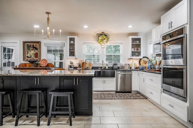 819 N Jefferson Ave, Cookeville, TN 38501 - kitchen featuring appliances with stainless steel finishes, a sink, glass insert cabinets, a kitchen bar, and white cabinets