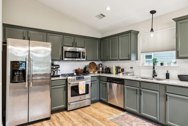 143 Two Mile Pike, Goodlettsville, TN 37072 - kitchen with stainless steel appliances, a sink, decorative backsplash, vaulted ceiling, and light stone countertops