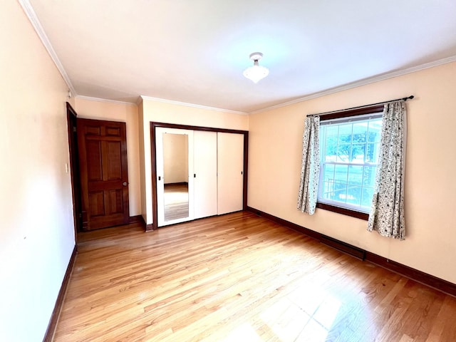 565 E College St, Pulaski, TN 38478 - unfurnished bedroom featuring baseboards, a closet, ornamental molding, and light wood-style floors