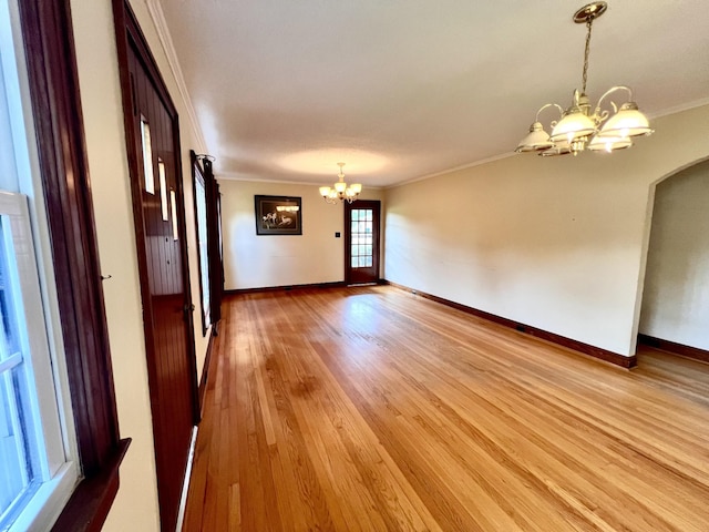 565 E College St, Pulaski, TN 38478 - empty room with a chandelier, ornamental molding, light wood finished floors, baseboards, and arched walkways