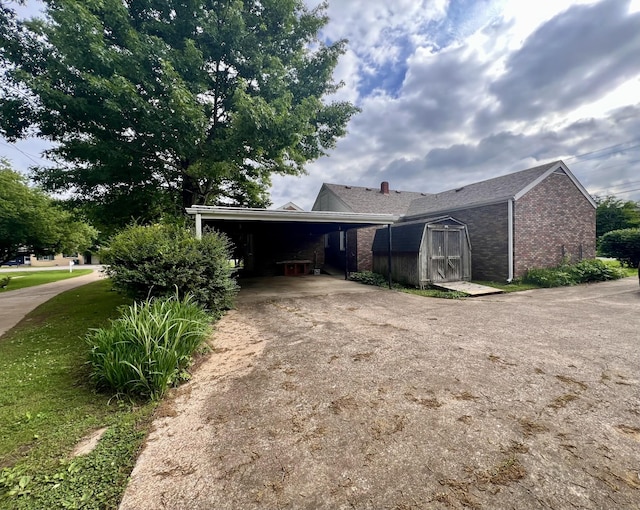 565 E College St, Pulaski, TN 38478 - view of property exterior featuring asphalt driveway, brick siding, and an attached carport