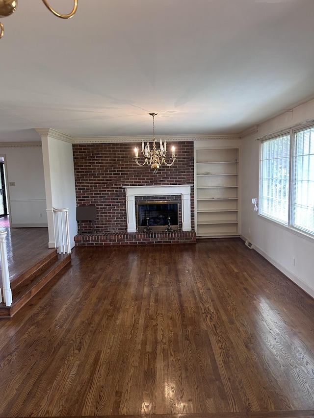 314 Powder Mill Dr, Ashland City, TN 37015 - unfurnished living room featuring a brick fireplace, baseboards, built in features, dark wood-type flooring, and ornamental molding
