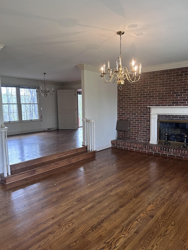 314 Powder Mill Dr, Ashland City, TN 37015 - unfurnished living room featuring a chandelier, crown molding, wood finished floors, a brick fireplace, and baseboards