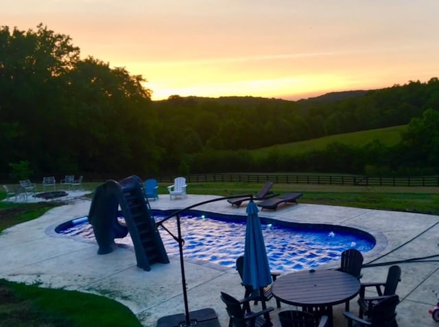 4095 Indian Hills Rd, Columbia, TN 38401 - pool at dusk featuring a fire pit, a patio, and a wooded view