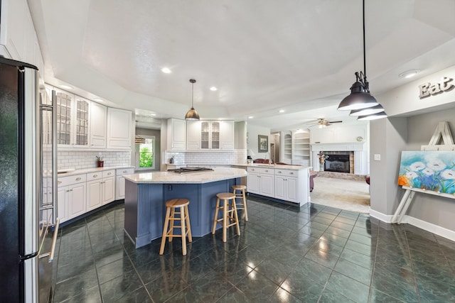 4095 Indian Hills Rd, Columbia, TN 38401 - kitchen featuring stainless steel appliances, a center island, a fireplace with raised hearth, backsplash, and recessed lighting