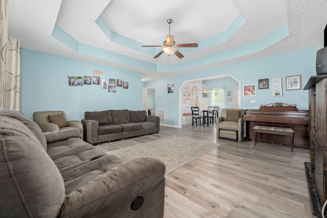 278 Riddle Rd, Manchester, TN 37355 - living area featuring a ceiling fan, a tray ceiling, light wood-style floors, and baseboards