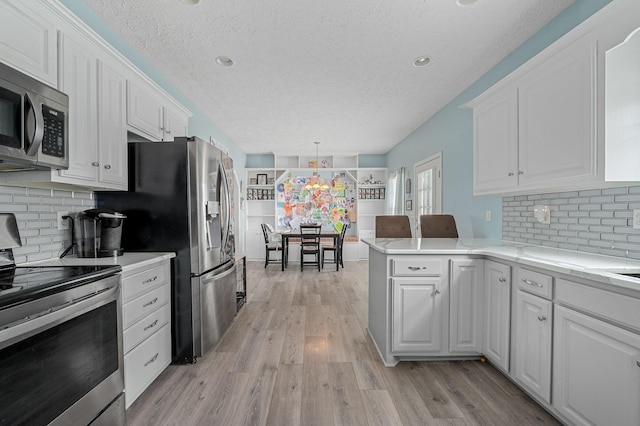 278 Riddle Rd, Manchester, TN 37355 - kitchen featuring appliances with stainless steel finishes, a textured ceiling, white cabinetry, and light wood-style flooring