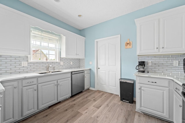 278 Riddle Rd, Manchester, TN 37355 - kitchen with a sink, dishwasher, white cabinetry, and tasteful backsplash