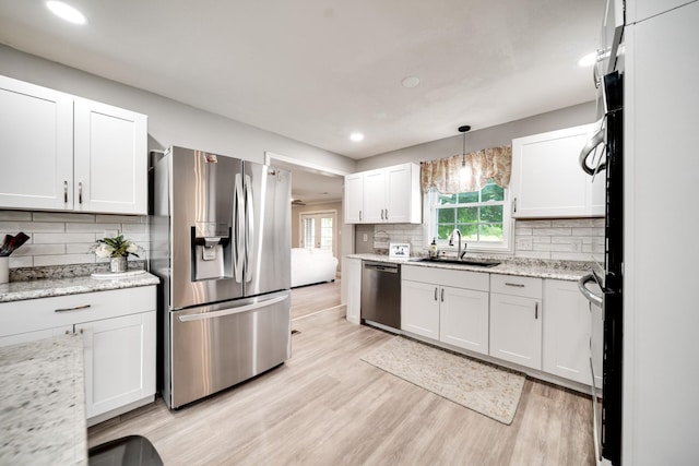 1112 Belmont Dr, Cookeville, TN 38506 - kitchen with stainless steel appliances, a sink, light wood-style floors, backsplash, and white cabinetry