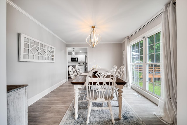 1112 Belmont Dr, Cookeville, TN 38506 - dining area featuring healthy amount of natural light, a chandelier, ornamental molding, wood finished floors, and baseboards
