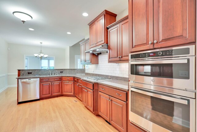 358 Spring Valley Dr, Cottontown, TN 37048 - kitchen featuring appliances with stainless steel finishes, a sink, a chandelier, a peninsula, and light wood-style floors