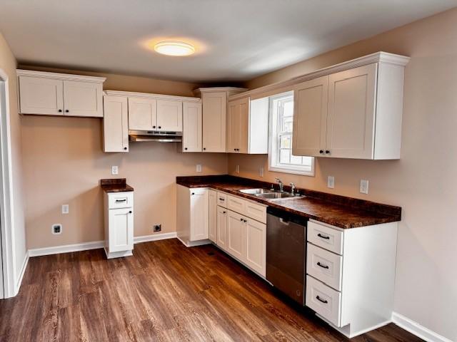 62 Modena Pl, Decherd, TN 37324 - kitchen with dishwasher, a sink, dark wood-style floors, dark countertops, and baseboards