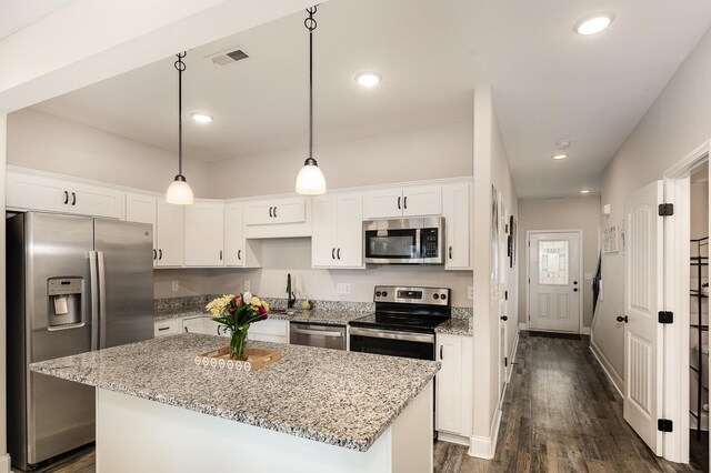 328 Fallow Cir, Clarksville, TN 37040 - kitchen featuring appliances with stainless steel finishes, white cabinets, a center island, dark wood-type flooring, and light stone counters