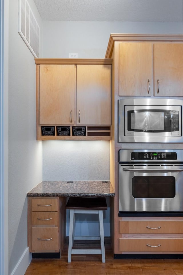 2600 Hillsboro Pike Unit 453, Nashville, TN 37212 - kitchen with stainless steel appliances, dark wood-style floors, baseboards, and dark stone countertops