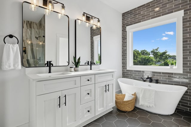 2211 18th Ave N, Nashville, TN 37208 - bathroom featuring tile walls, double vanity, a stall shower, a freestanding bath, and tile patterned floors