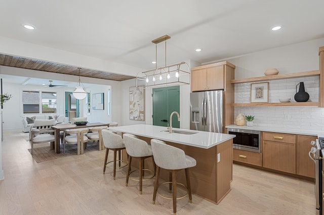 301B Oriel Ave, Nashville, TN 37210 - kitchen featuring stainless steel appliances, open shelves, a sink, light wood-style flooring, and a center island with sink
