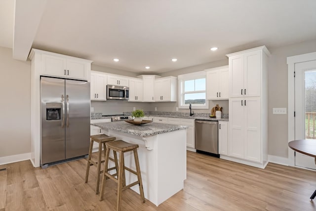 1515 Ellie Claire Way, Lewisburg, TN 37091 - kitchen with stainless steel appliances, light wood-style flooring, white cabinetry, a center island, and recessed lighting