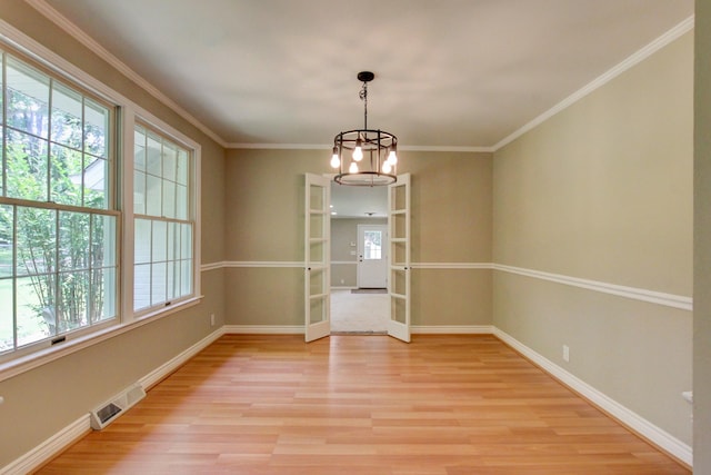339 Thompson Ln, Clarksville, TN 37040 - spare room with light wood-style floors, a chandelier, baseboards, crown molding, and french doors