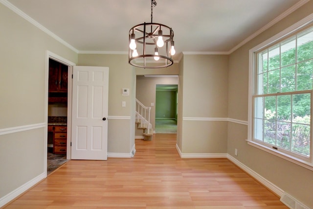 339 Thompson Ln, Clarksville, TN 37040 - empty room with light wood finished floors, a chandelier, baseboards, crown molding, and stairway