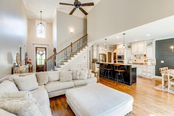 2007 Brisbane Dr, Spring Hill, TN 37174 - living area featuring a towering ceiling, a ceiling fan, stairs, wood finished floors, and ornamental molding