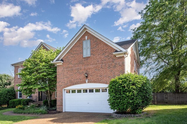 909 Miranda Pl, Franklin, TN 37067 - view of home's exterior with an attached garage, brick siding, and driveway