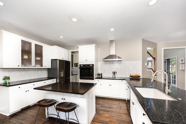 909 Miranda Pl, Franklin, TN 37067 - kitchen featuring wall chimney range hood, black appliances, a sink, dark wood-type flooring, and recessed lighting