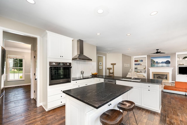909 Miranda Pl, Franklin, TN 37067 - kitchen with wall oven, wall chimney exhaust hood, a sink, a peninsula, and black electric cooktop