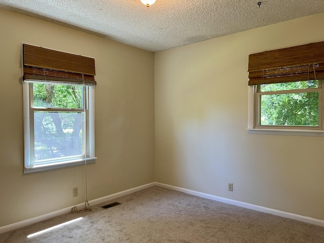 unfurnished room featuring carpet flooring, a textured ceiling, and baseboards