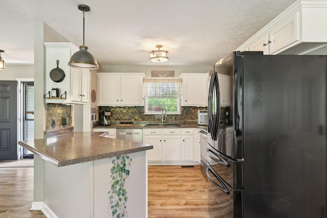 2277 Belotes Ferry Rd, Lebanon, TN 37087 - kitchen with freestanding refrigerator, a sink, dishwasher, dark countertops, and white cabinets