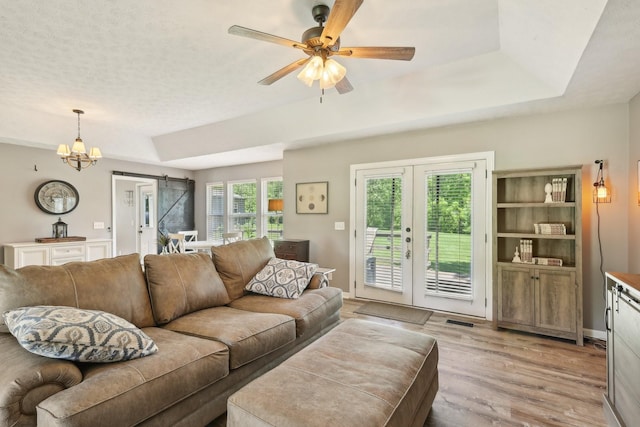 2277 Belotes Ferry Rd, Lebanon, TN 37087 - living area featuring a barn door, a raised ceiling, light wood-style flooring, ceiling fan, and a chandelier