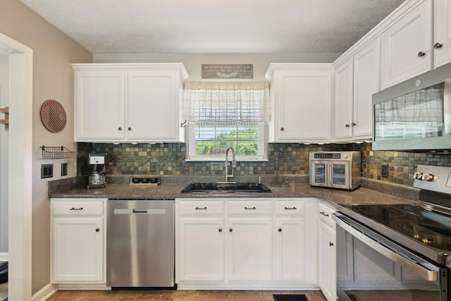 2277 Belotes Ferry Rd, Lebanon, TN 37087 - kitchen with appliances with stainless steel finishes, a sink, white cabinetry, backsplash, and dark stone counters