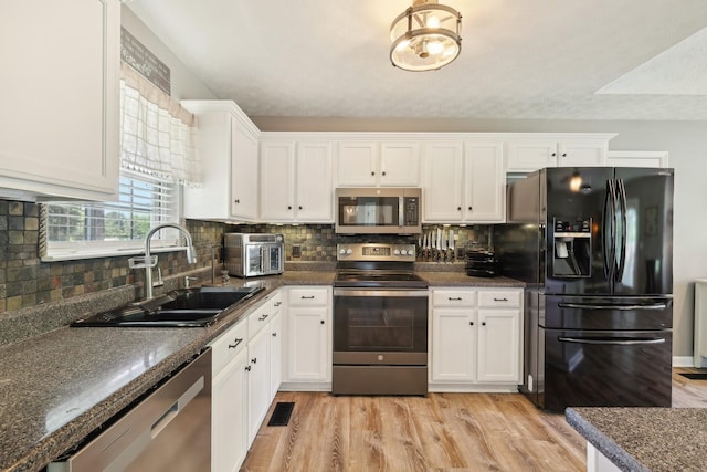 2277 Belotes Ferry Rd, Lebanon, TN 37087 - kitchen featuring appliances with stainless steel finishes, a sink, white cabinets, dark countertops, and backsplash