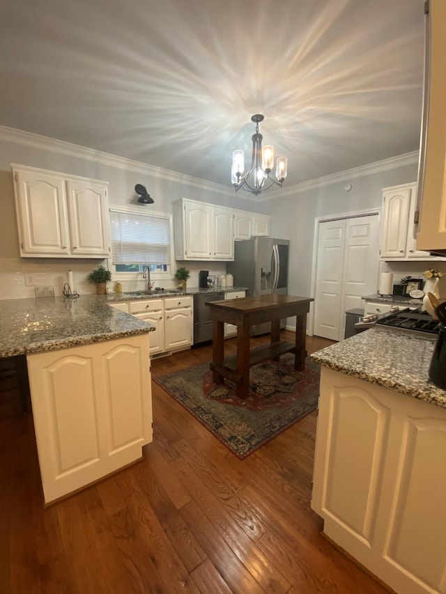 415 Ashley Ln, Kingston Springs, TN 37082 - kitchen with appliances with stainless steel finishes, white cabinets, crown molding, dark wood-style flooring, and a chandelier