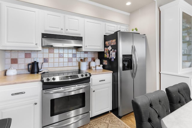 209 Woods Dr, Columbia, TN 38401 - kitchen with appliances with stainless steel finishes, under cabinet range hood, light countertops, ornamental molding, and tasteful backsplash