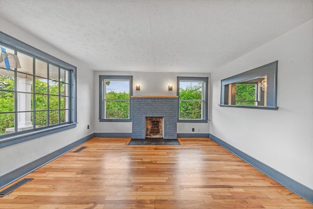 512 Transit Ave, Columbia, TN 38401 - unfurnished living room featuring plenty of natural light, a textured ceiling, wood finished floors, and baseboards