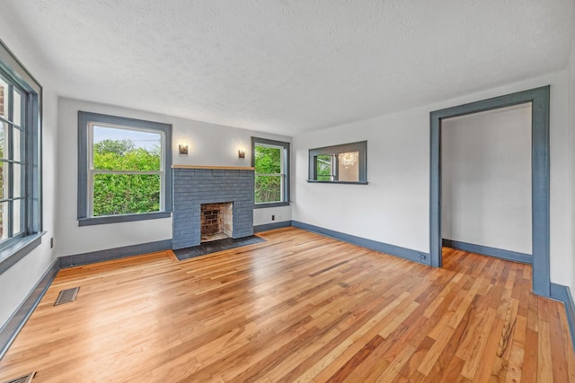 512 Transit Ave, Columbia, TN 38401 - unfurnished living room featuring wood finished floors, a textured ceiling, a fireplace, and baseboards