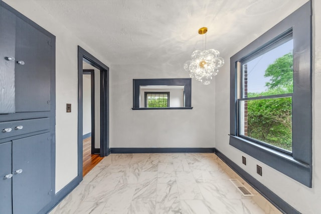 512 Transit Ave, Columbia, TN 38401 - unfurnished dining area with light marble finish flooring, baseboards, and a chandelier