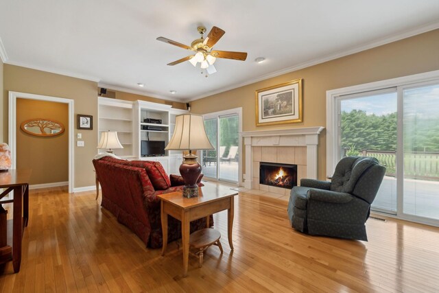 2305 Black Fox Ct, Murfreesboro, TN 37127 - living area with light wood-type flooring, ceiling fan, ornamental molding, a tiled fireplace, and baseboards