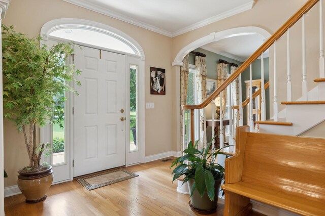 2305 Black Fox Ct, Murfreesboro, TN 37127 - entryway featuring wood finished floors, crown molding, arched walkways, stairway, and baseboards