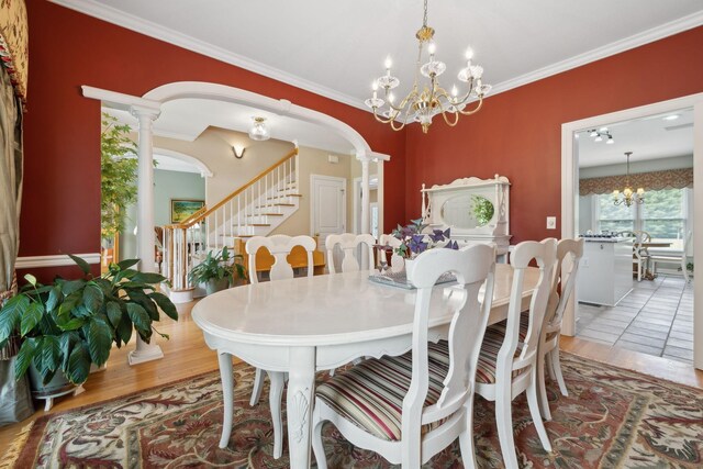 2305 Black Fox Ct, Murfreesboro, TN 37127 - dining room with a chandelier, stairway, crown molding, wood finished floors, and decorative columns