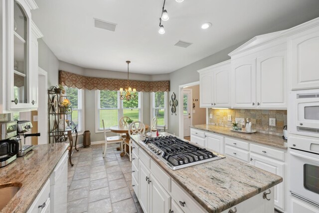 2305 Black Fox Ct, Murfreesboro, TN 37127 - kitchen with white appliances, a chandelier, tasteful backsplash, white cabinets, and a center island