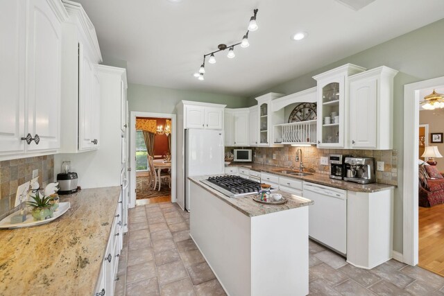 2305 Black Fox Ct, Murfreesboro, TN 37127 - kitchen featuring white appliances, a sink, white cabinets, a kitchen island, and backsplash
