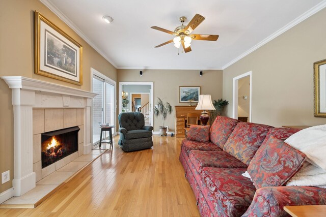 2305 Black Fox Ct, Murfreesboro, TN 37127 - living area featuring light wood finished floors, a ceiling fan, crown molding, a tile fireplace, and baseboards