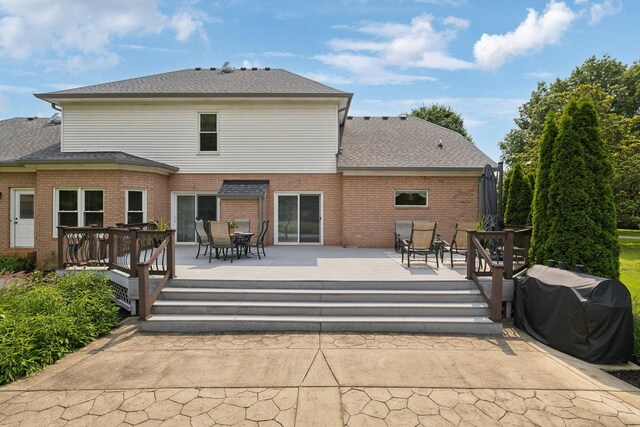 2305 Black Fox Ct, Murfreesboro, TN 37127 - rear view of house featuring outdoor dining space, brick siding, roof with shingles, and a wooden deck