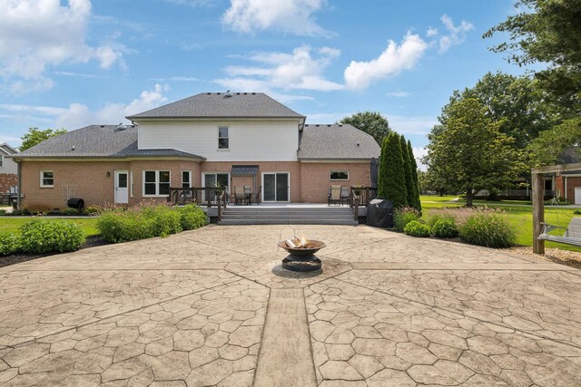 2305 Black Fox Ct, Murfreesboro, TN 37127 - back of property featuring a patio area, a fire pit, a wooden deck, brick siding, and a shingled roof
