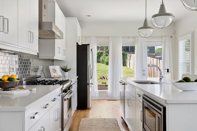 814A Horner Ave, Nashville, TN 37204 - kitchen with stainless steel appliances, a sink, light wood-style flooring, wall chimney range hood, and healthy amount of natural light